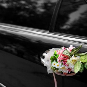 Door of black wedding car with flowers