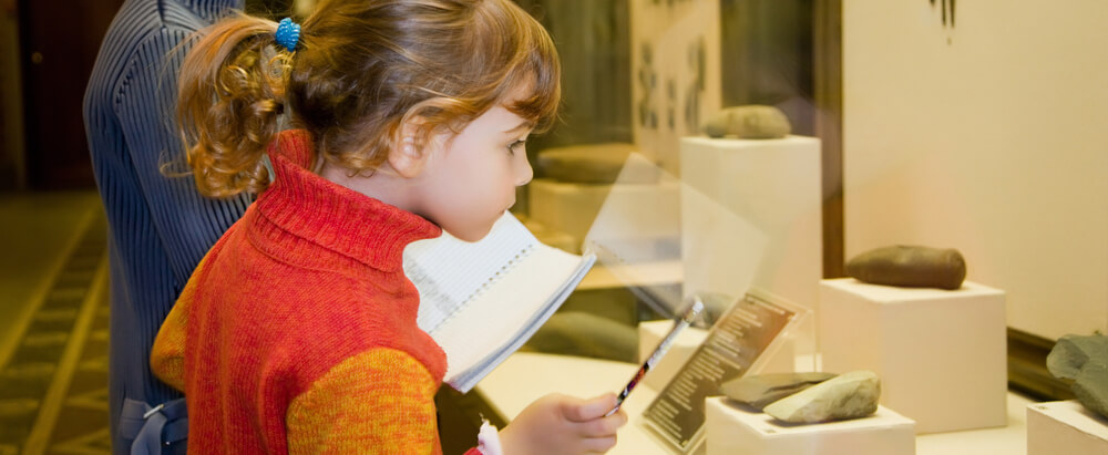 Boy and little girl at excursion in historical museum near exhib